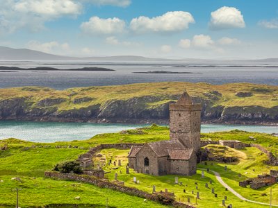 Aerial view of St Clements Church near coastal edge and grassy cliffs, near Roghadal south of Leverburgh, Isle of Harris, Outer Hebrides, Scotland