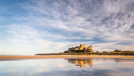 Bamburgh castle reflecting in the wet sand, Bamburgh, England