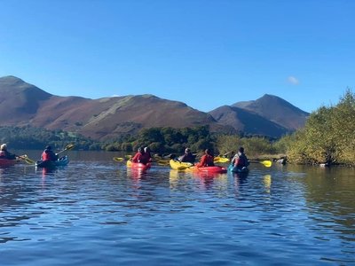 Group of women kayaking on Derwentwater Lake in the Lake District as part of Ramble Worldwide holiday Women's Activity Week