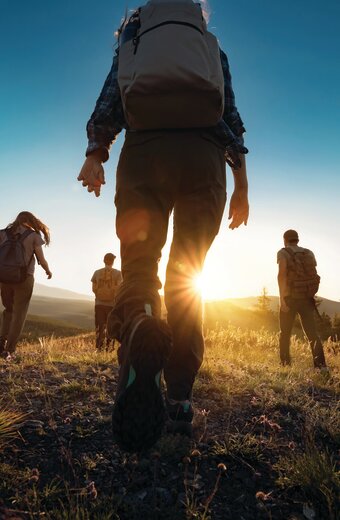 Group walking towards sun in Altai mountains, Siberia on a walking holiday