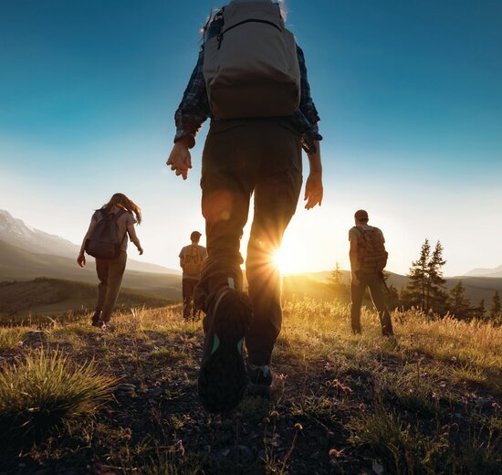 Group walking towards sun in Altai mountains, Siberia on a walking holiday