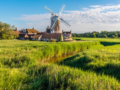 Village of Cley with large windmill and drainage channels in the marshes in Norfolk, UK