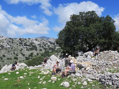 Walkers sat on rocks during short break in mountainous area, Sierra de Grazalema, Spain