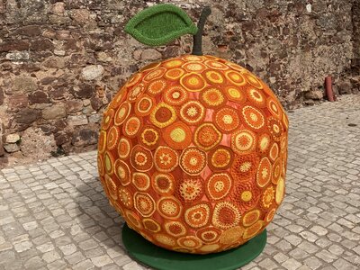 Giant knitted orange displayed in cobblestone street of Silves, Algarve, Portugal