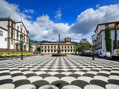 Cityscape of the town square Praca do Municipio with the Church of St. John the Evangelist and the city hall, on a summer day with blue sky and clouds, Funchal, Madeira, Portugal