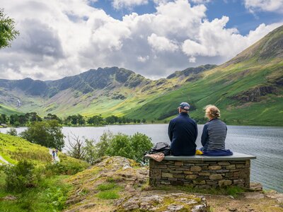 Couple enjoying view of Buttermere Lake and mountainous landscape in the Lake District, Cumbria