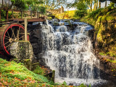 Vintage red waterwheel with waterfall in autumn colours in Glenariff Forest Park, Count Antrim, Northern Ireland