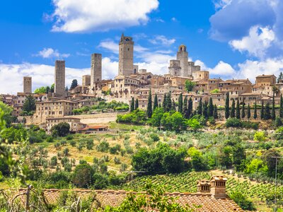 Medieval San Gimignano seen from afar amongst hilly landscape, Tuscany, Italy