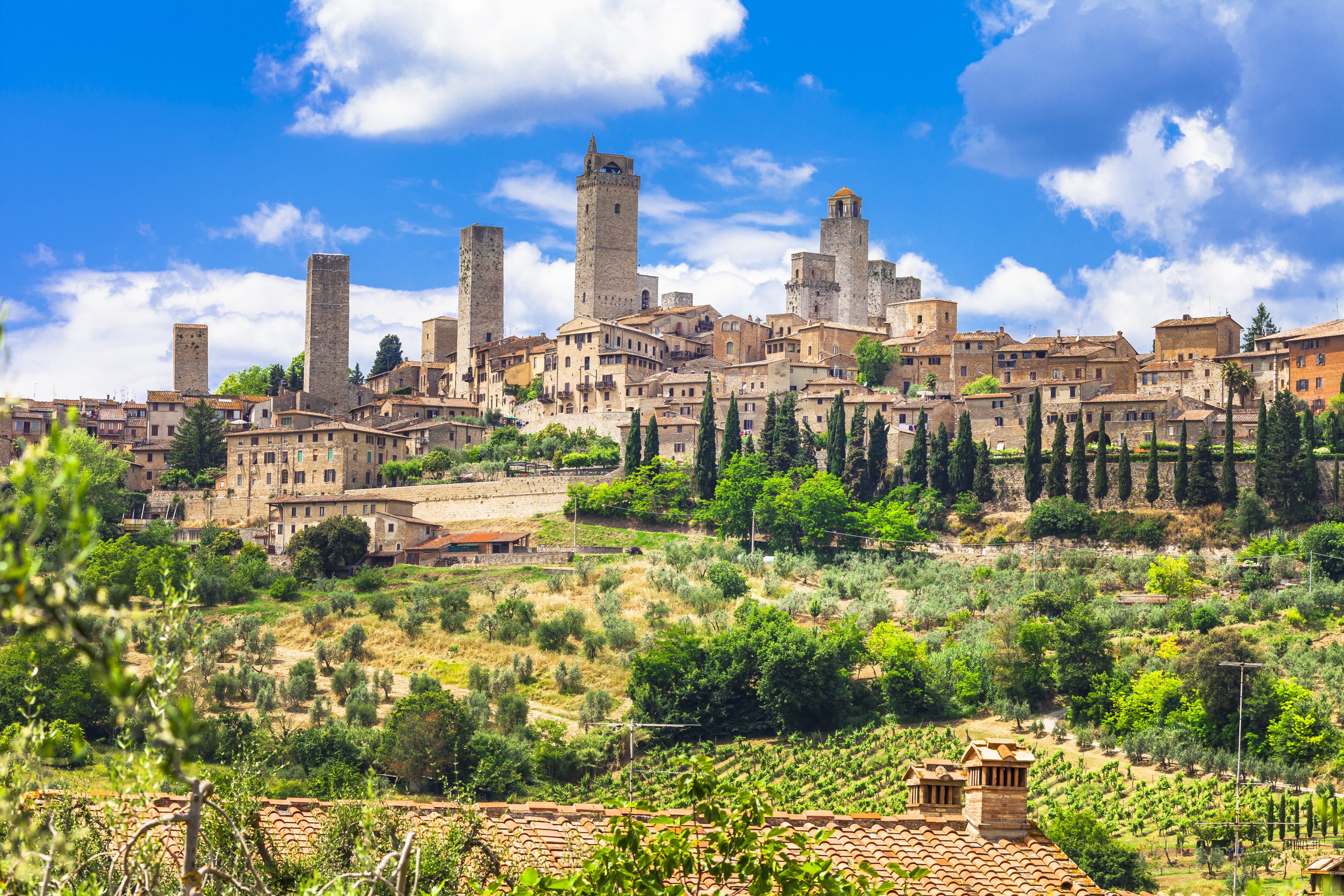 Medieval San Gimignano seen from afar amongst hilly landscape, Tuscany, Italy