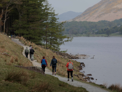 Ramble Worldwide group walking uphill on trail around Buttermere Lake, Lake District
