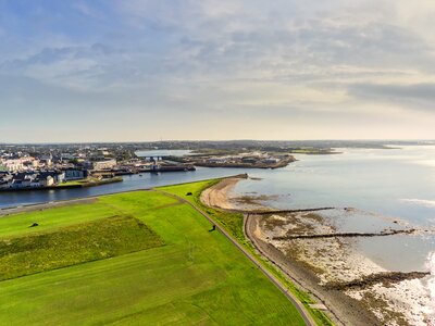 Aerial view of Galway port with River Corrib flowing into Atlantic ocean on sunny warm day, Ireland