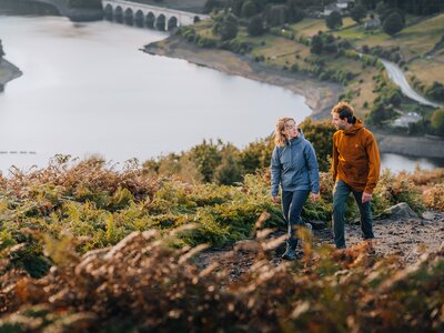Man and a woman hiking in the countryside in outdoor clothing