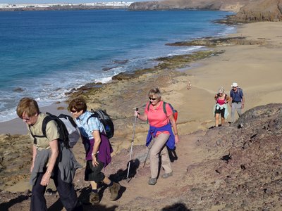 Ramble Worldwide walking group ascending rocky coastal path in Playa Blanca, Lanzarote, Canary Islands, Spain