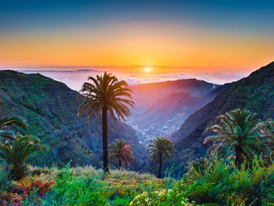 Tropical scenery with palm trees and mountain valleys during sunrise in Canary Islands, Spain