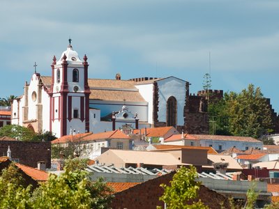 Silves Cathedral towering above surrounding houses on sunny day, Algarve, Portugal