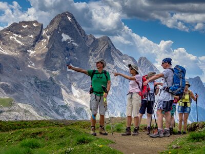 Walk leader guiding a group through the Dolomites, Italy, pointing the way ahead