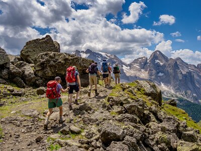 walking group trekking through the Dolomites, Italy towards far peaks