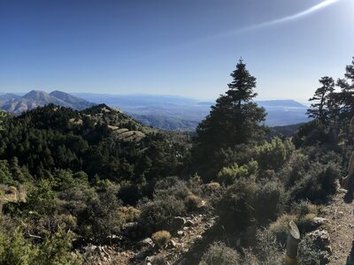 Wide angle shot of female hiker starring into distance at mountain range landscape of Sierra de las Nieves, Andalucia, Spain